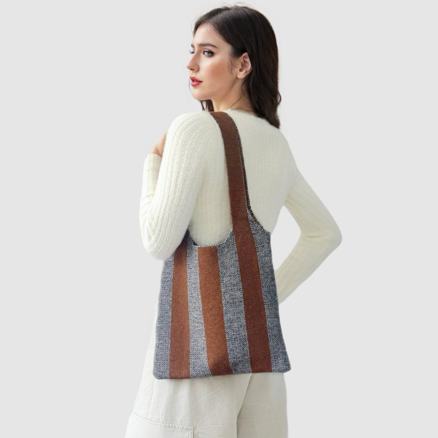 Model carrying a wool bag on the shoulder Bold Band Knit Bag in ocher, ideal for city walks and gifting.