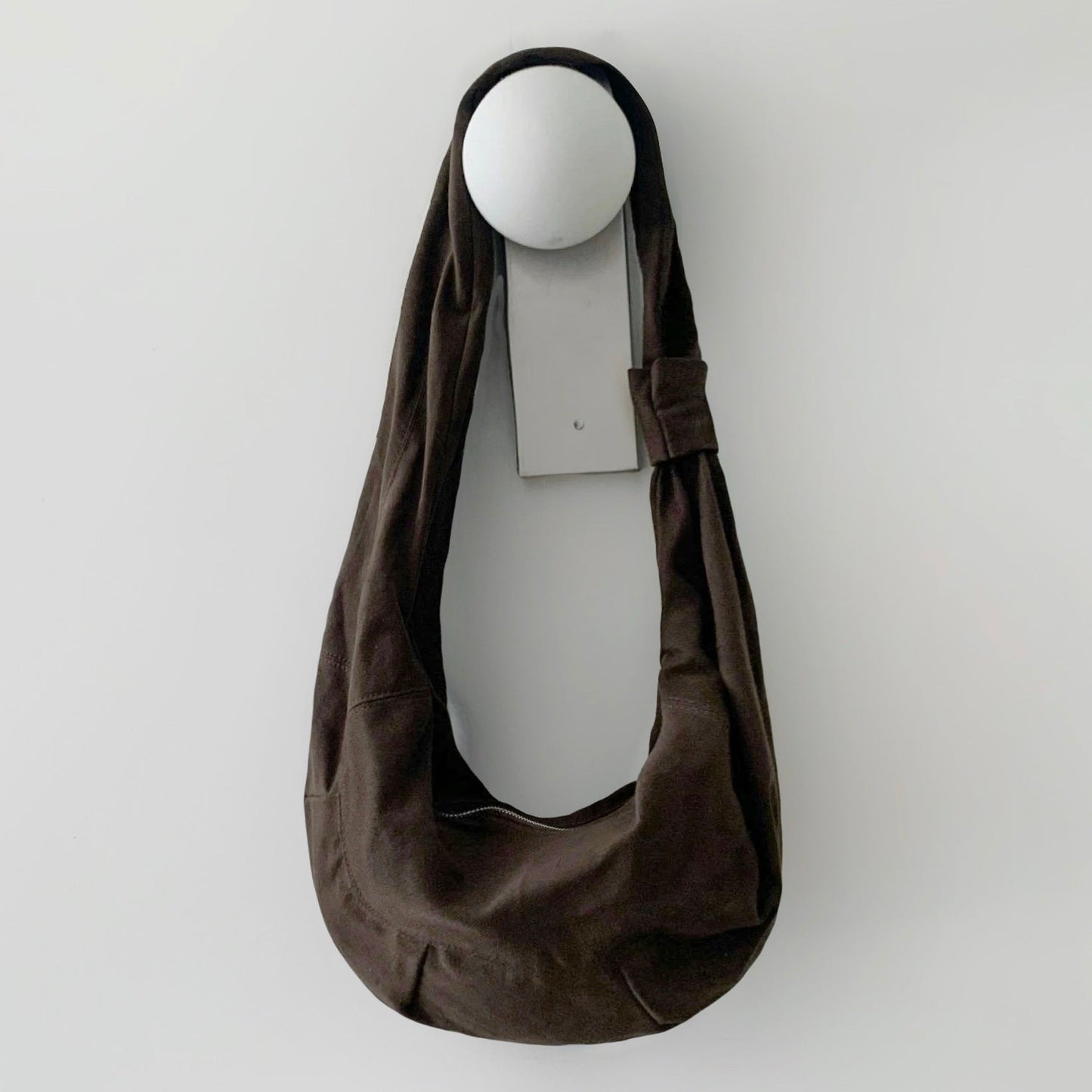Dark brown corduroy crescent bag showcasing its soft ribbed texture.