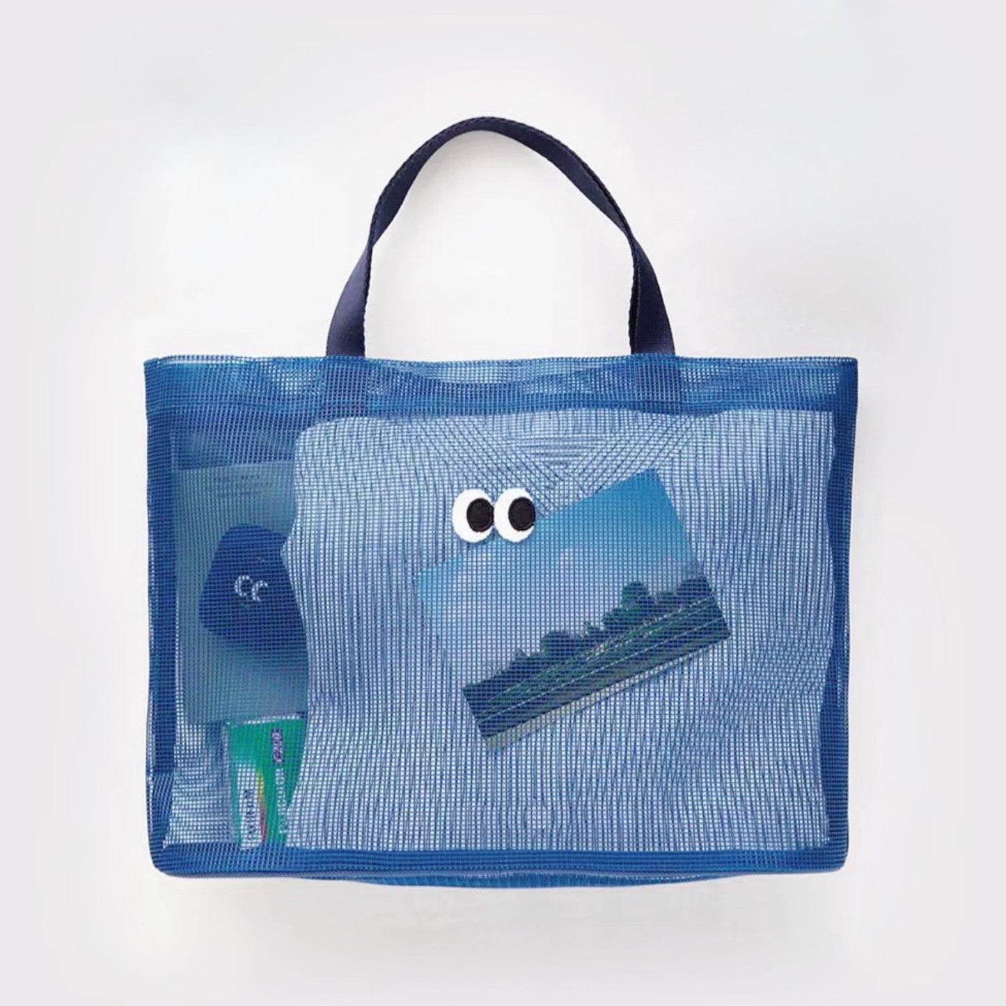 Folded view of Googly Eyes Mesh Tote Bag in navy blue, easy for commuting and weekends.