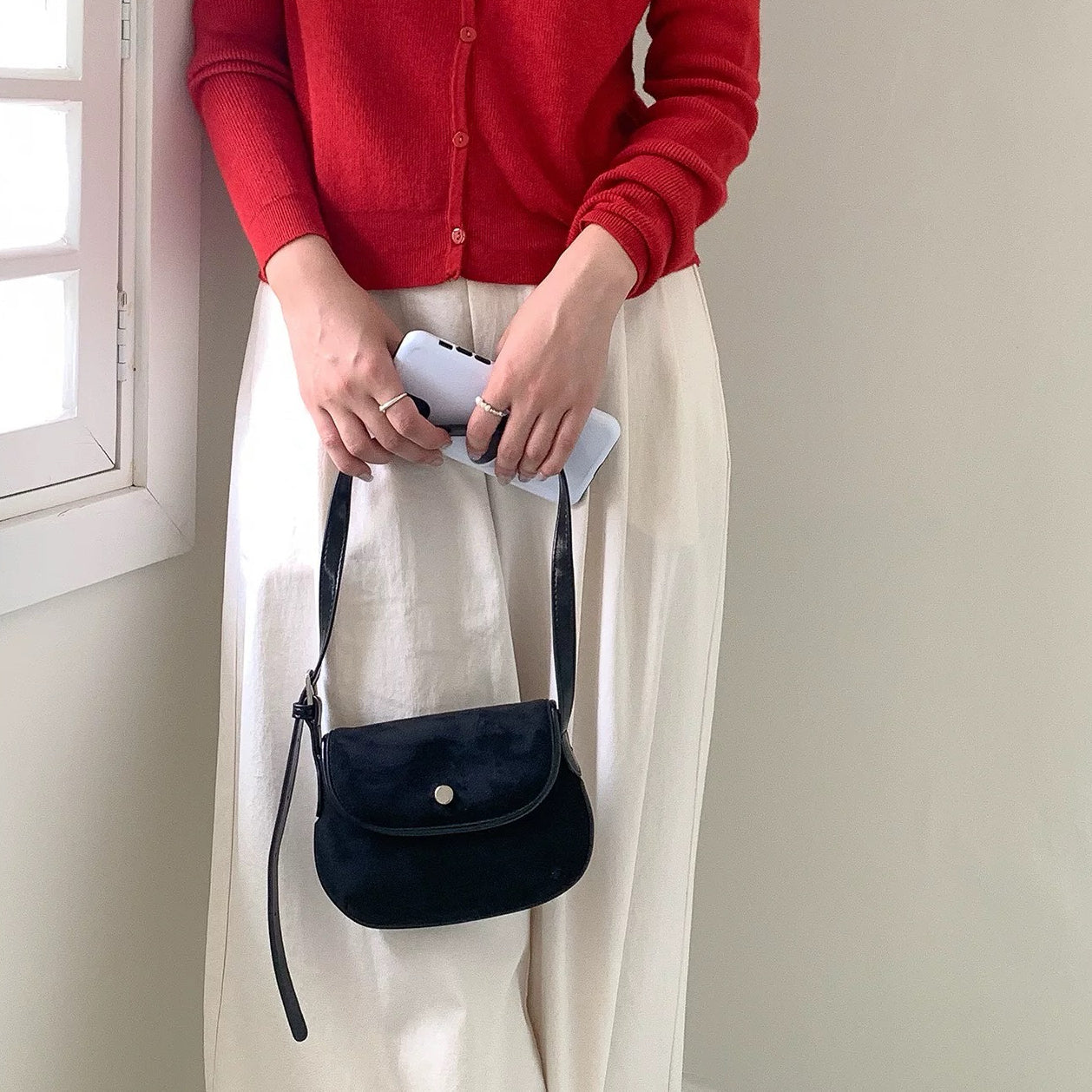 Model holding the classic black saddle bag with a minimalist look.