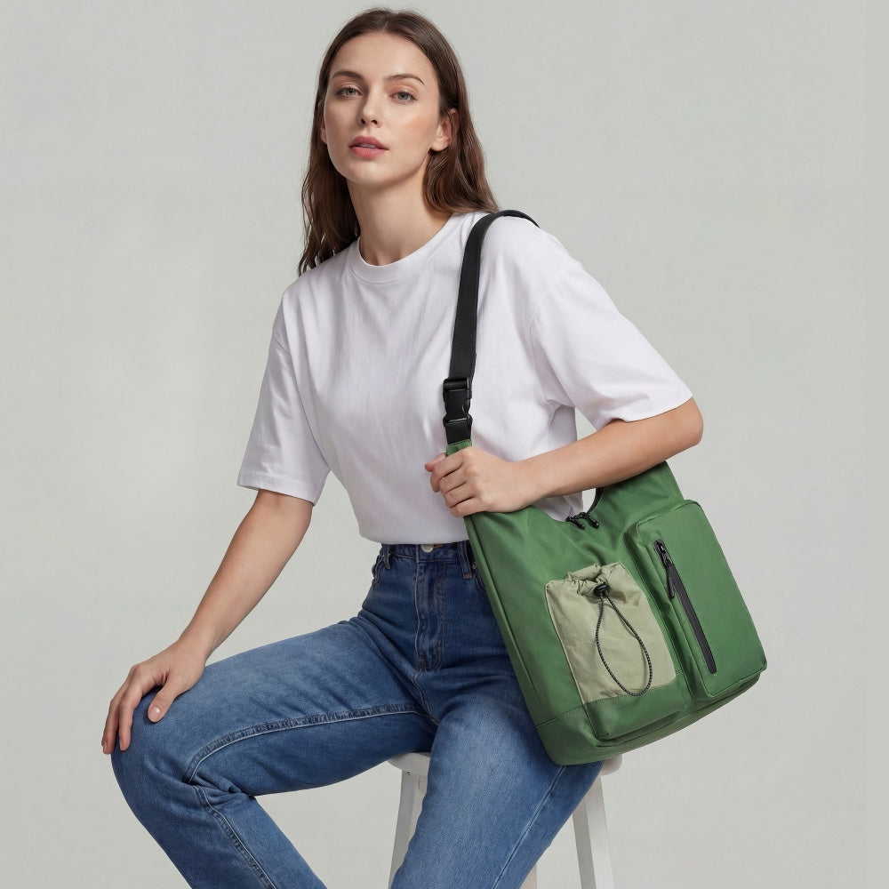 Model wearing the green multi-pocket nylon bag on shoulder.
