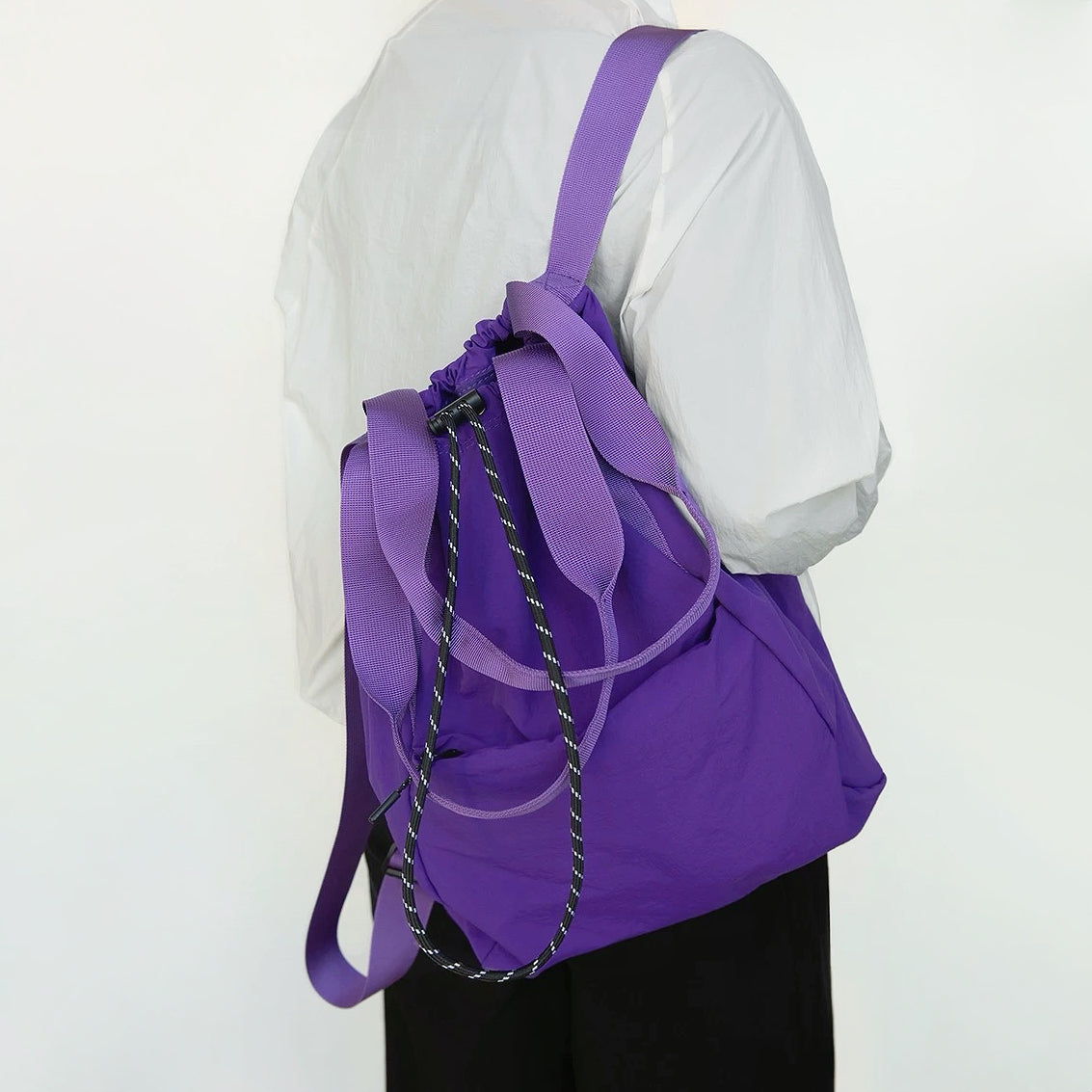 Rear view of the purple 2-way bag used as a backpack, demonstrating the comfortable shoulder straps and drawstring details.