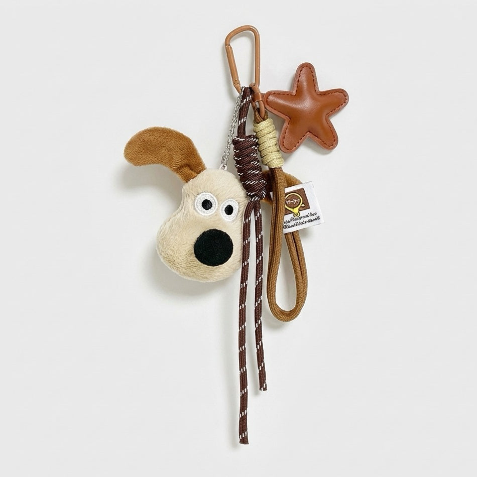Close-up of the Super Dog plush bag charm with carabiner, ropes and star.