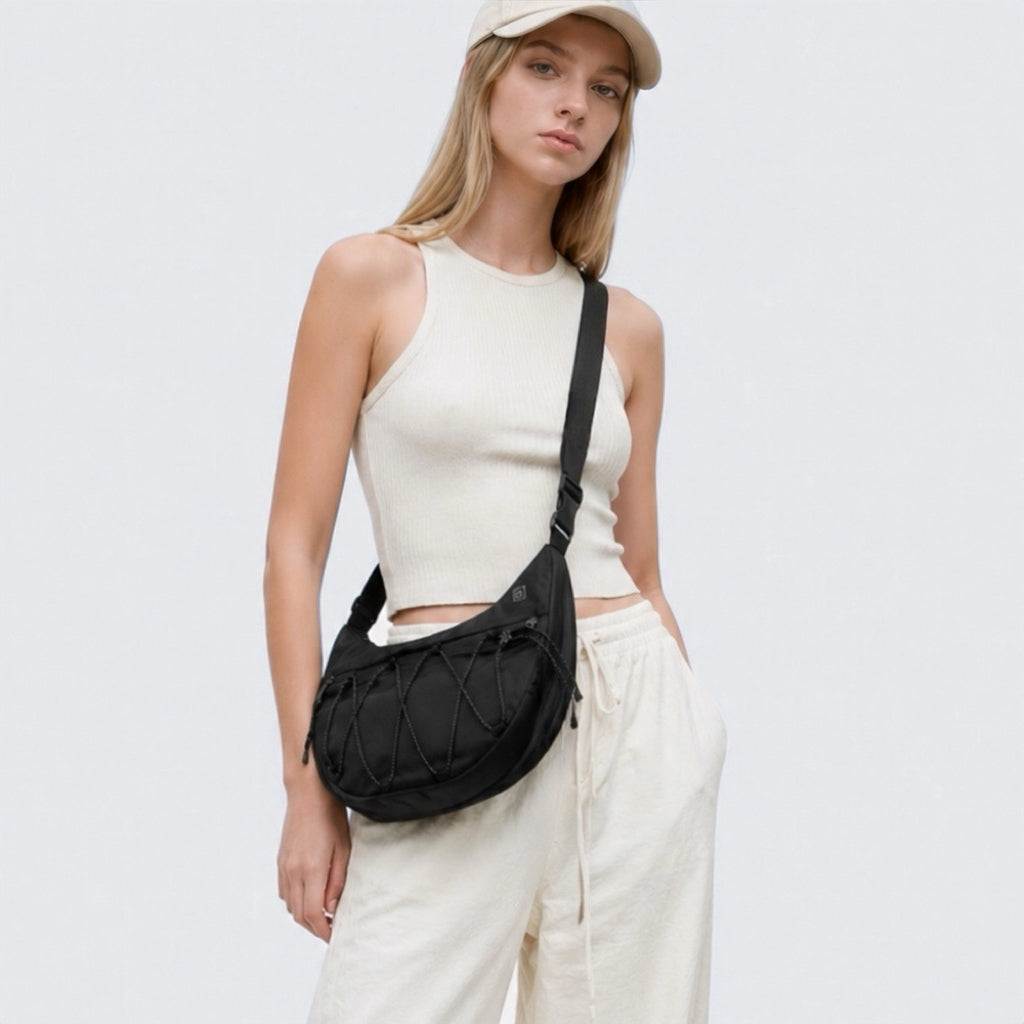 Model wearing a black lightweight nylon crescent sling bag as crossbody, showcasing the effortless urban style.