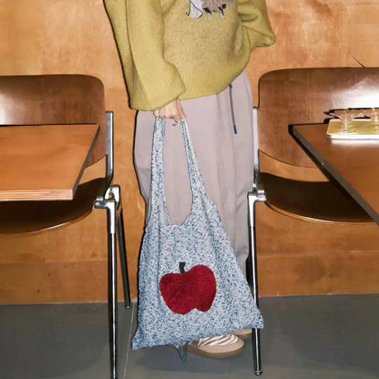 Model carrying an Apple Whimsy Knit Bag handheld , great for daily carry and travel.