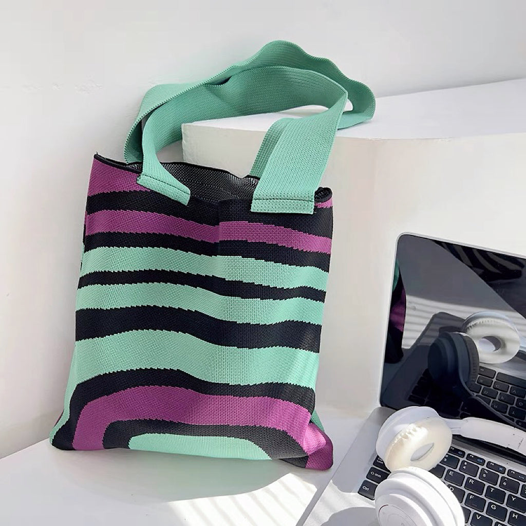Close-up of  Arc Line Knitted Bag in green and purple, ideal for errands and gifting.