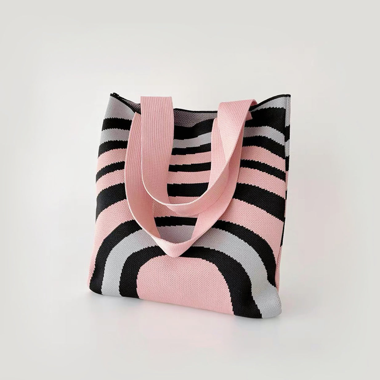 Close-up of  Arc Line Knitted Bag in pink and grey, ideal for errands and gifting.