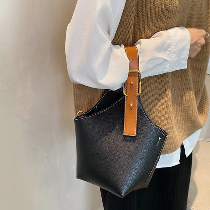 Model carrying a black  Balloon Bucket Bag handheld, great for daily carry and travel.