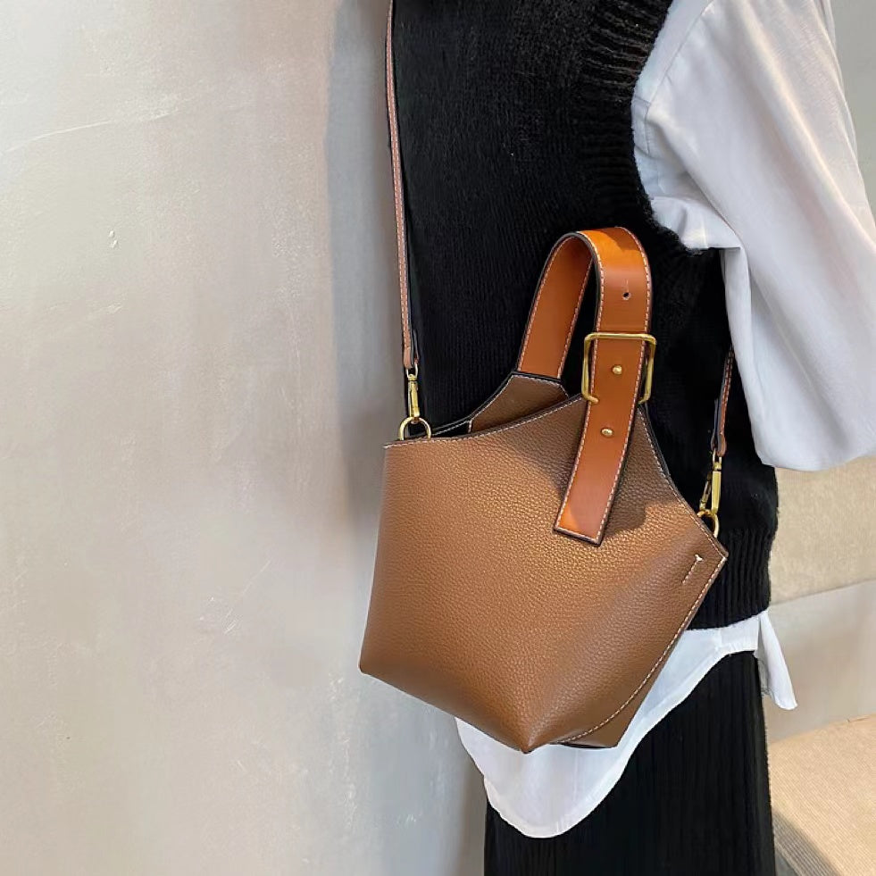 Angled view of model carring a tan Balloon Bucket Bag as crossbody bag, easy for commuting and weekends.