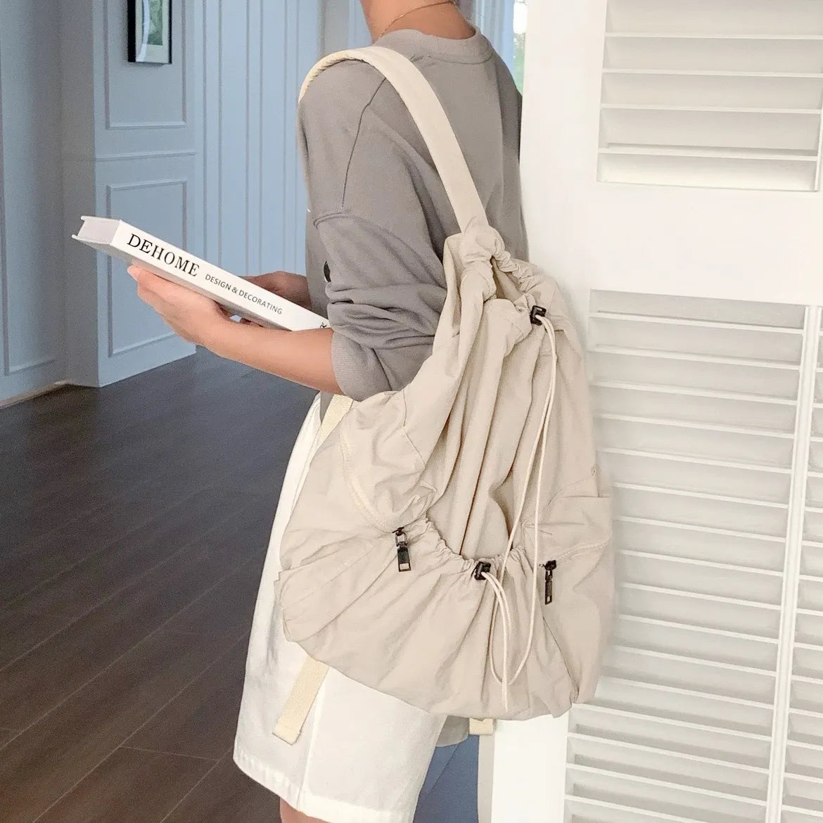 Model wearing beige foldable backpack featuring ultralight polyester and secure drawstring storage.