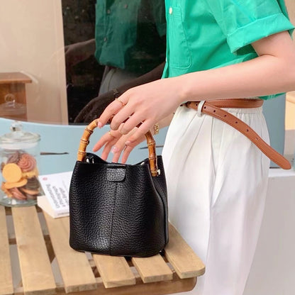 A model carrying the bamboo handle bucket bag in black, showcasing its elegant vintage aesthetic for daily wear.