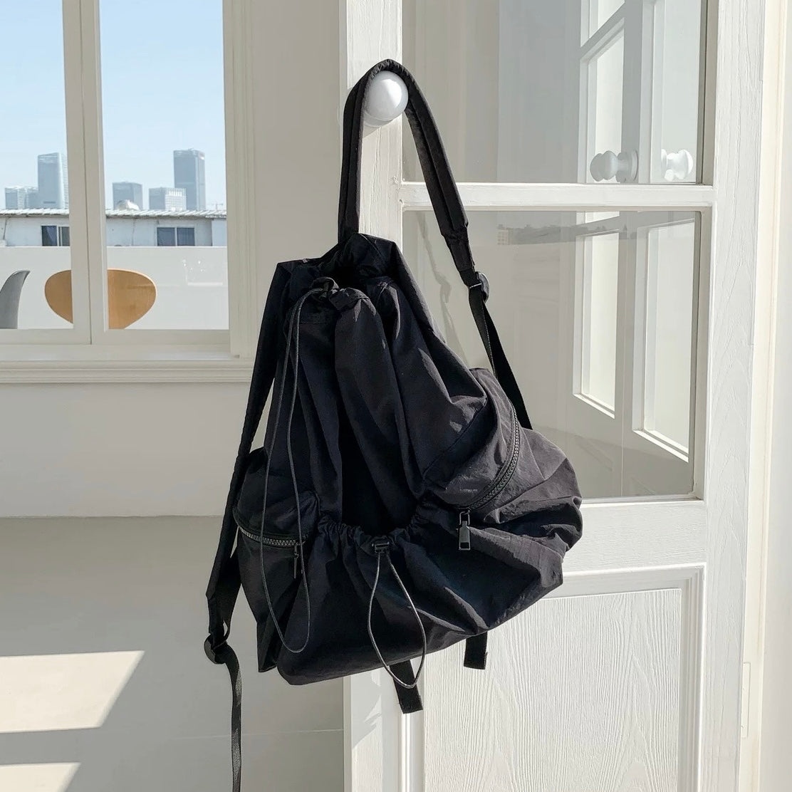 Black foldable backpack featuring ultralight polyester and secure drawstring storage.