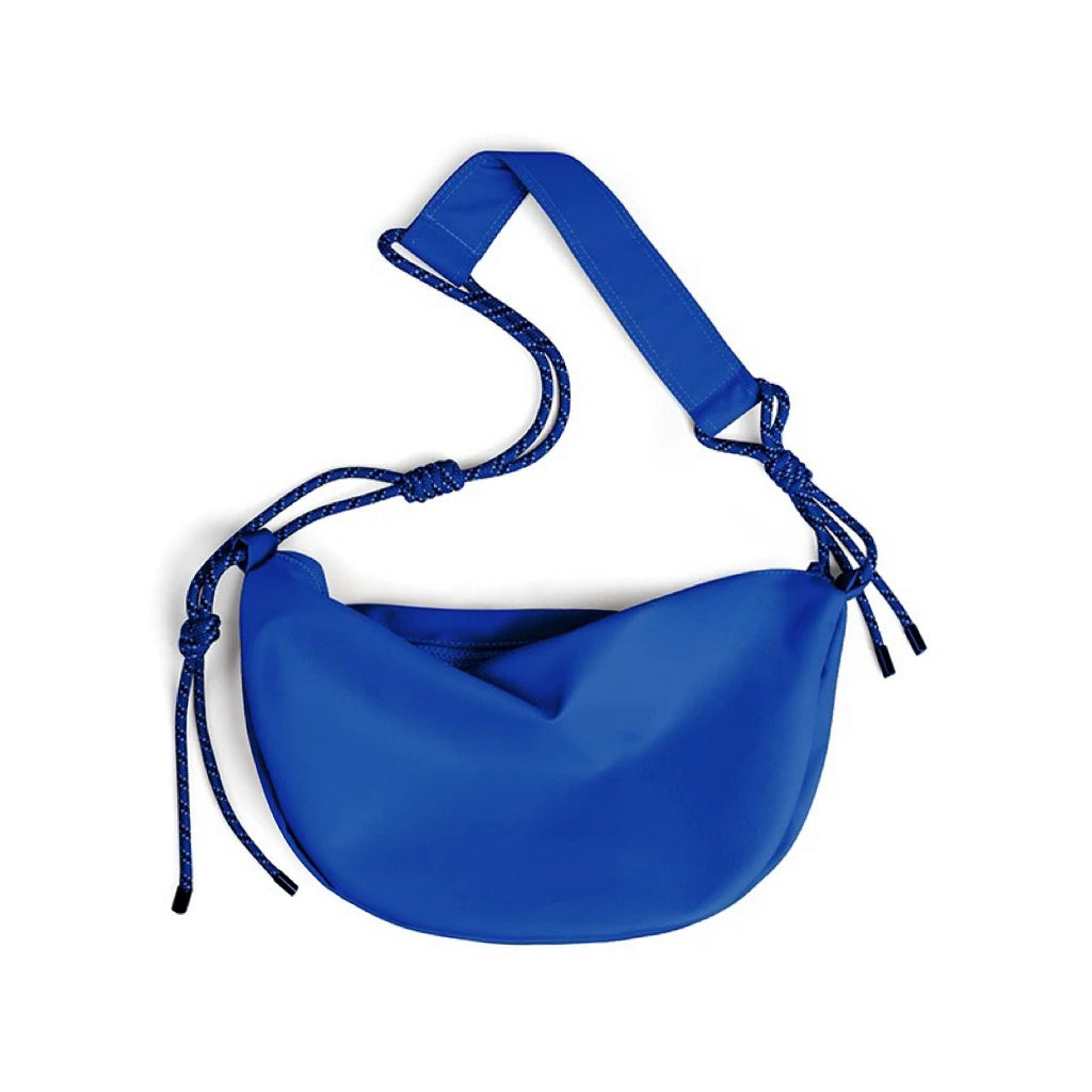 Blue structured crescent bag made of lightweight nylon, showing the seamless zip-top and curved silhouette.