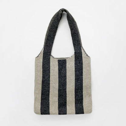 Close-up of Wool blend knit bag with bold black and beige vertical stripes and a shoulder strap wool shoulder bag.