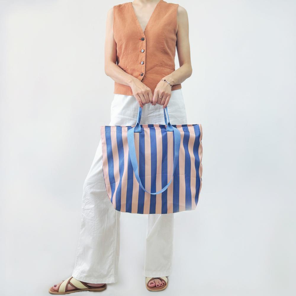 Model carrying a violet Bold Color Striped Tote Bag handheld, great for daily carry and travel.
