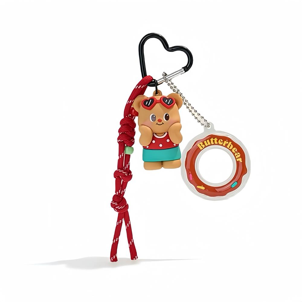 Flat lay of  Butter Bear Bag Charm with red rope and heart-shaped keyring, ideal for everyday outfits and street style.