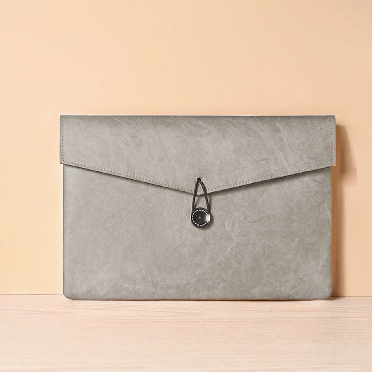 Angled view of Buttoned Envelope Laptop Sleeve bag in gray, great for everyday carry and travel.
