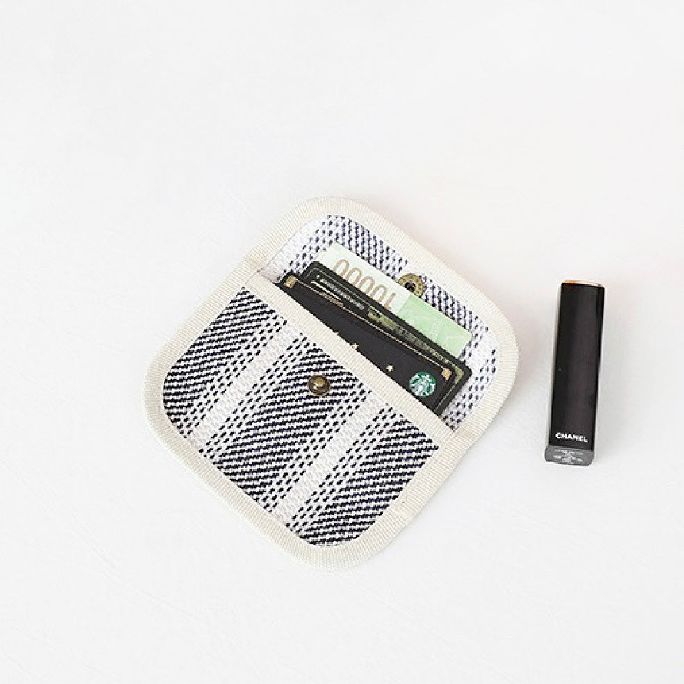 Black-and-white plaid canvas coin purse showing cards inside; snap-flap pocket wallet for travel and shopping.