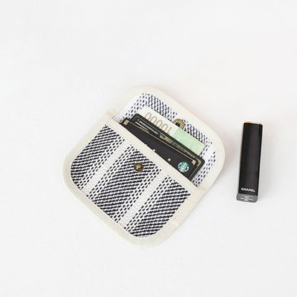 Black-and-white plaid canvas coin purse showing cards inside; snap-flap pocket wallet for travel and shopping.