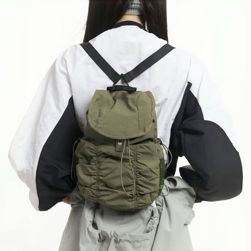 Back view of model with olive pleated backpack; ergonomic design ideal for comfortable daily commuting.