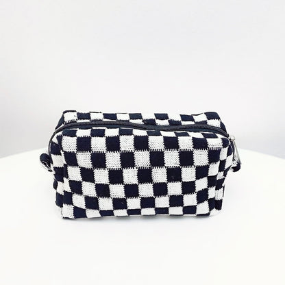 Classic black and white checkerboard knit bag; durable woven cosmetic pouch for timeless aesthetic fashion.
