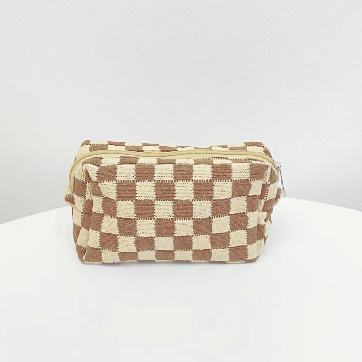 Coffee color of checkered knit makeup bag; versatile neutral accessory for cozy desk organization.
