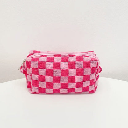 Front view of a hot pink checkerboard knit bag; soft textured crochet pouch for retro-modern style.
