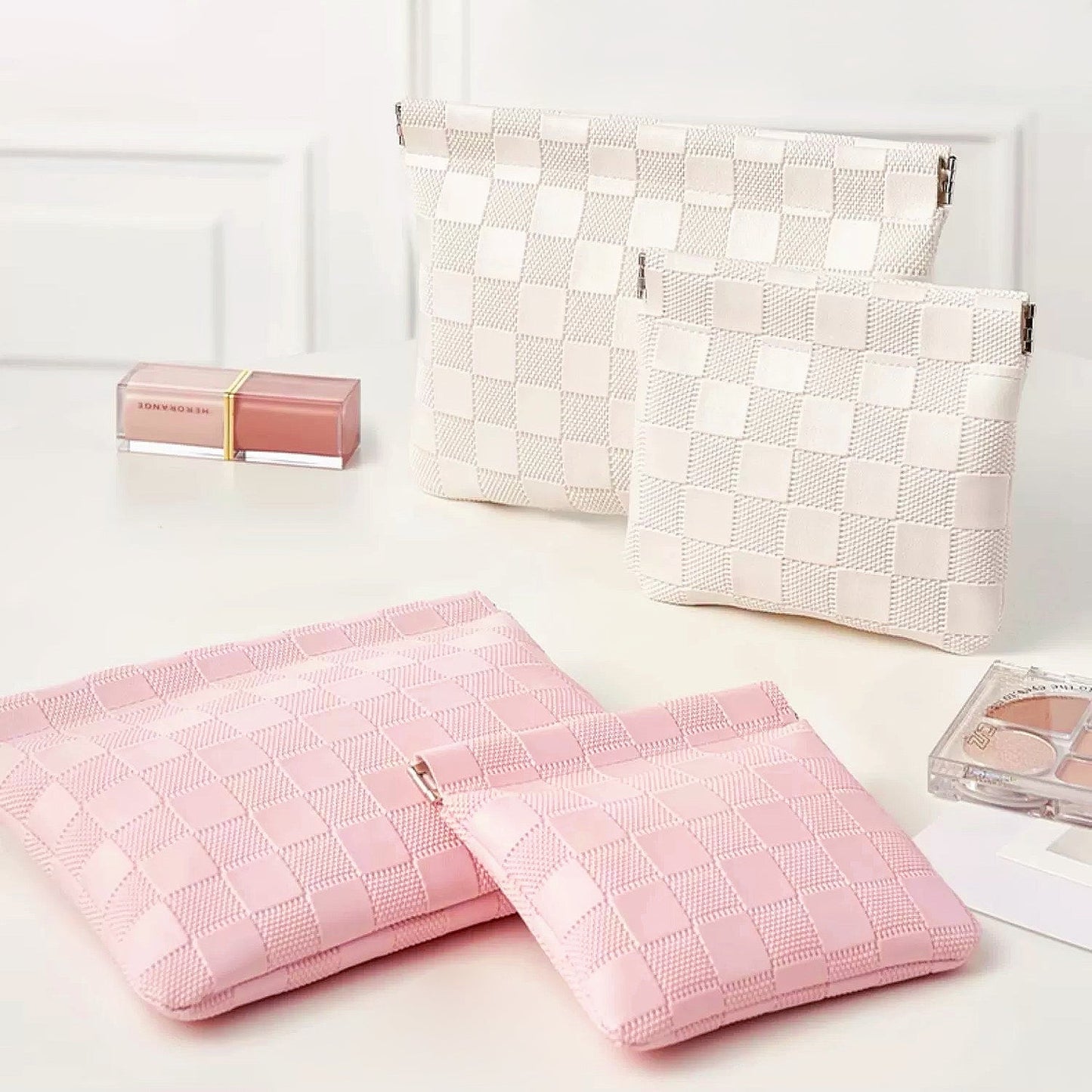Pink and white checkered self-closing bags in multiple sizes; woven checker pouches for travel and cosmetics.