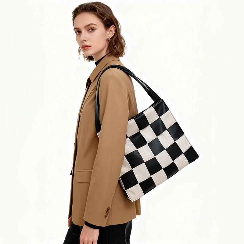 Model wearing a black and white checkered woven leather shoulder bag, ideal for stylish office commuting.