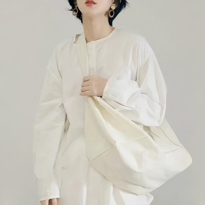 Model carrying a white bag as crossbody, great for daily carry and travel.