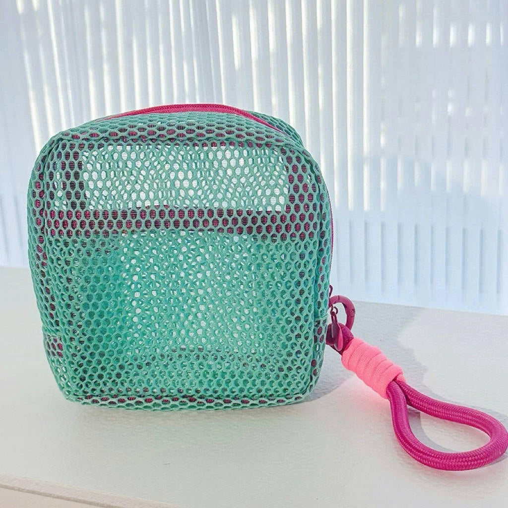 Mint Chroma mesh pouch with pink wrist lanyard; breathable zip organizer for travel toiletries and gadgets.