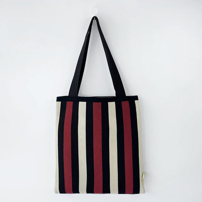 Folded view of Chromatic Stripe Knitted Bag in black and red, easy for commuting and weekends.
