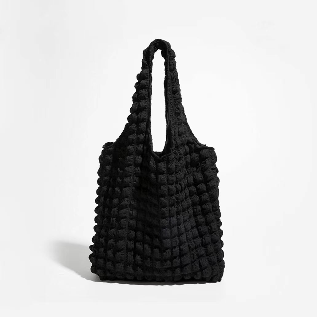 Front view of the black 3D bubble textured tote bag against a white background.