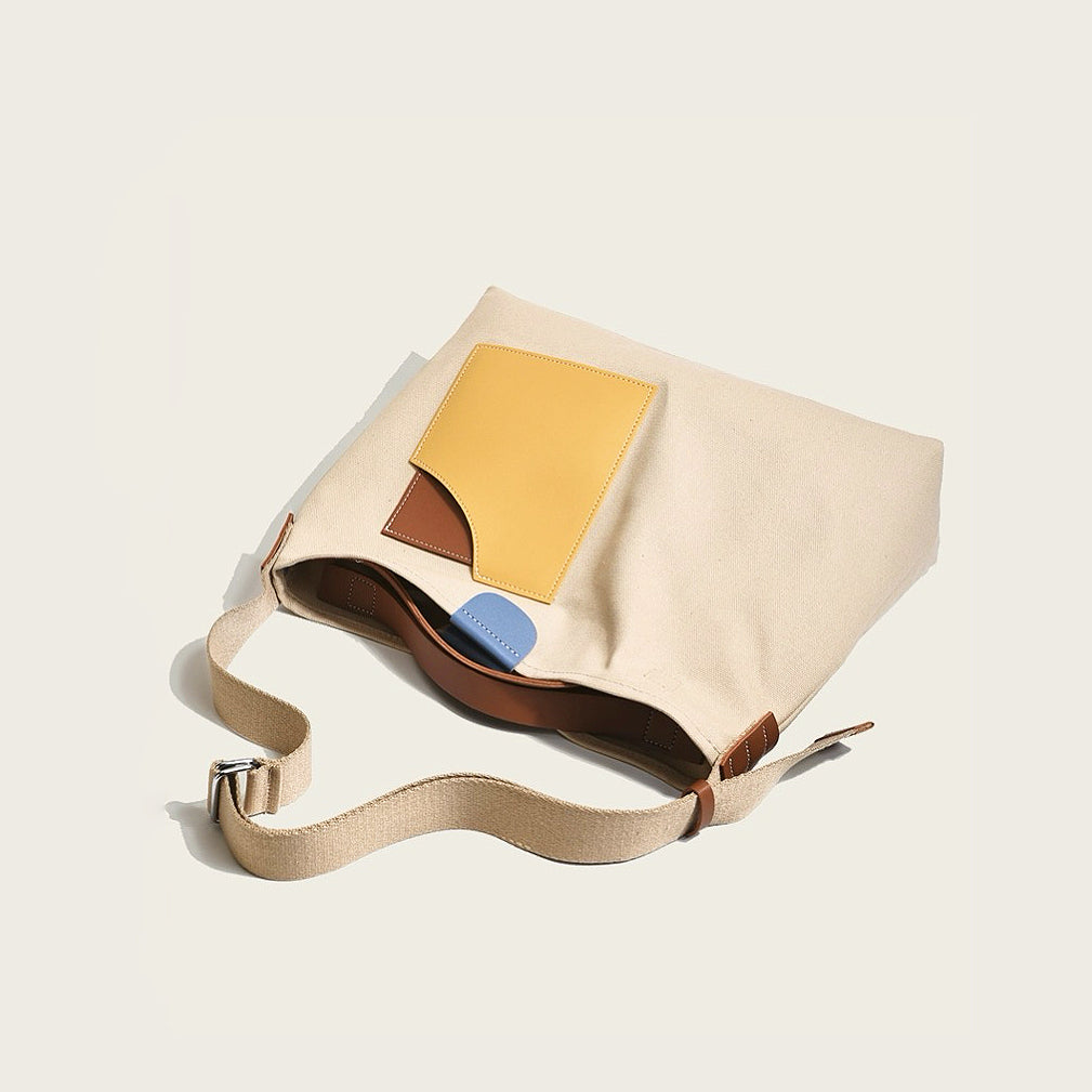 Detailed view of khaki canvas tote with yellow faux-leather accents emphasizing sturdy construction for daily shopping.