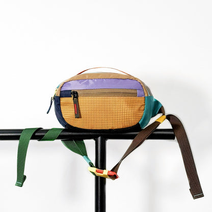 Yellow nylon belt bag displayed on a black metal stand and clean background.