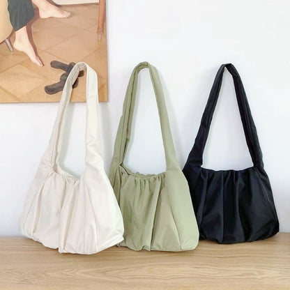 Three concise pleated shoulder bags in white, green, and black;  affordable minimalist nylon totes under $50.