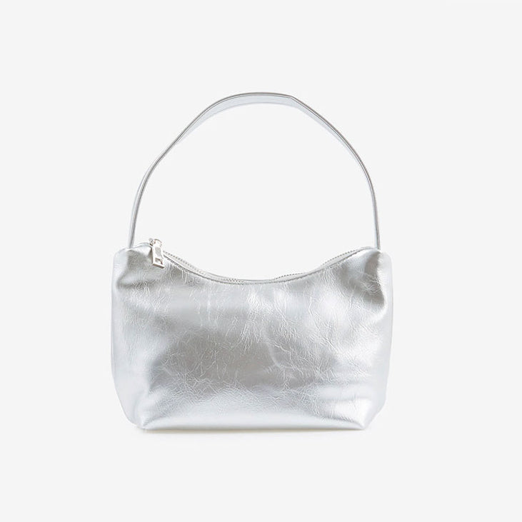 Angled view of Silver patent leather shoulder bag with a single strap and top zipper closure, easy for commuting.