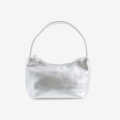 Angled view of Silver patent leather shoulder bag with a single strap and top zipper closure, easy for commuting.