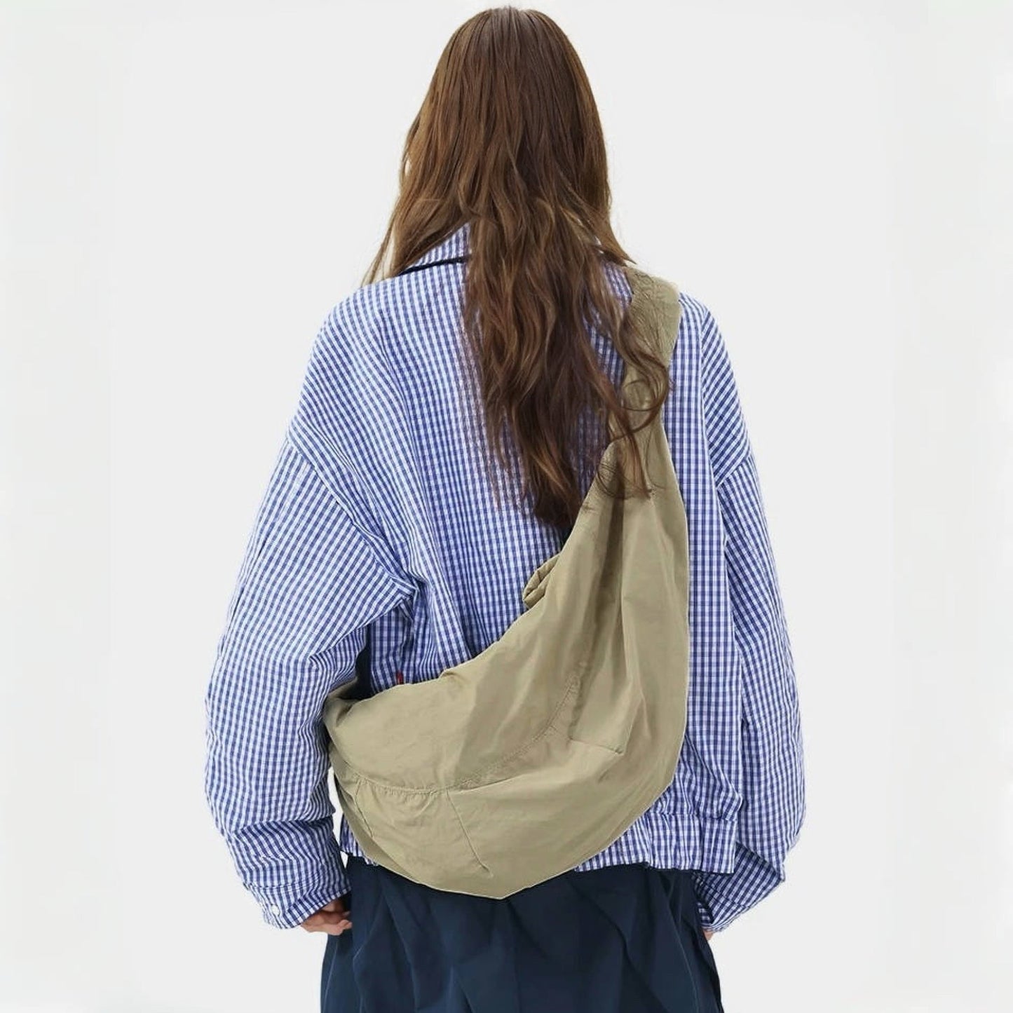 Back view of the model carrying the khaki corduroy crescent crossbody bag.