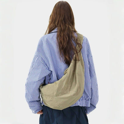 Back view of the model carrying the khaki corduroy crescent crossbody bag.
