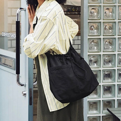 Model carrying a black nylon bag as crossbody, easy for commuting and weekends.