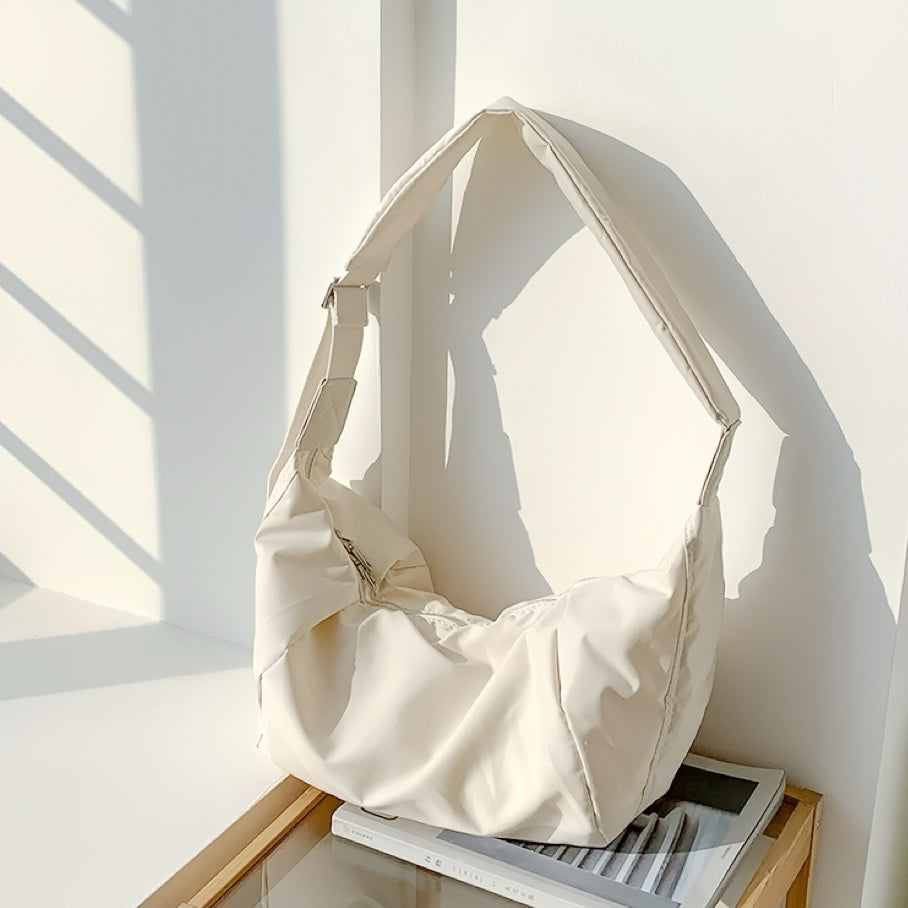 Creamy white padded bag with a clean, curved design, suitable for fresh aesthetic styling.