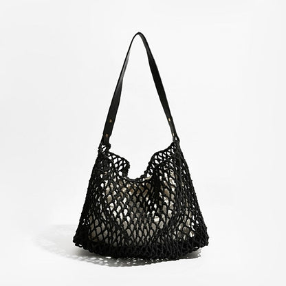 Angled view of Black crochet shoulder bag with a long leather strap and cotton rope net design, easy for commuting.