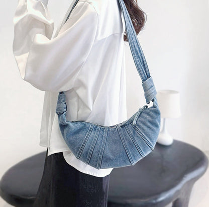 Model carrying a washed blue Croissant Denim Shoulder Bag on the shoulder, easy for commuting and weekends.