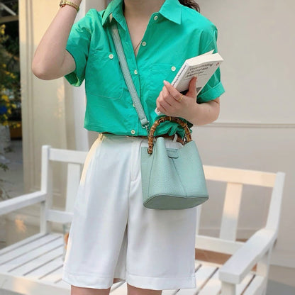 The cyan bucket bag with a long shoulder strap, perfect for effortless styling.