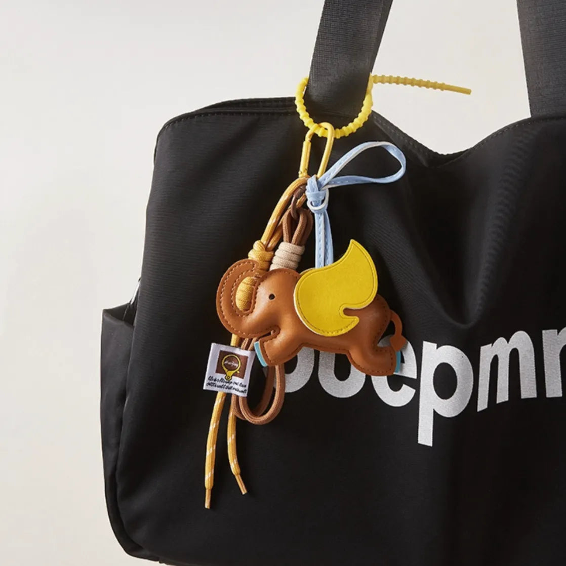 Dumbo Bag Charm hanging on a black tote bag, easy for gifting and photo-ready styling.
