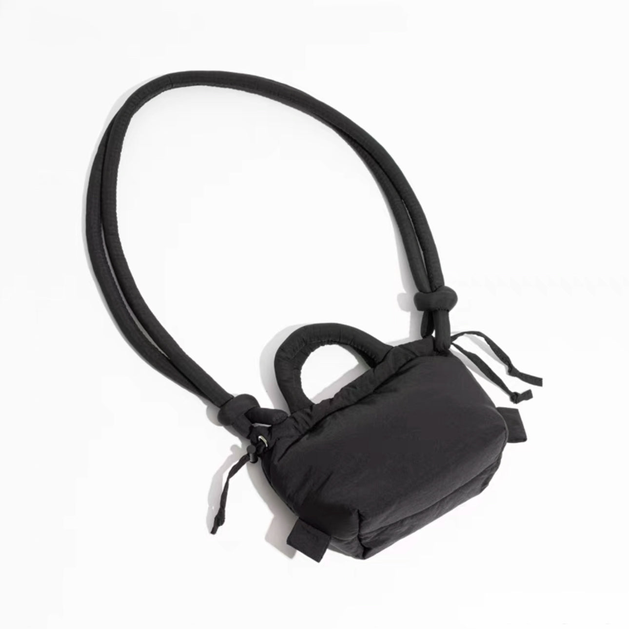 Top view of black multi use bag, showing the detail of the knot and padded fabric.