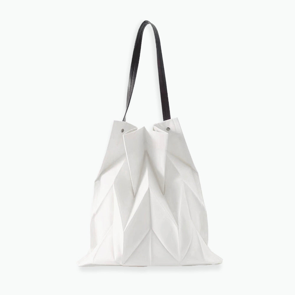 Front view of white pleated shopper bag; sleek geometric texture ideal for pairing with summer dresses and light outfits.