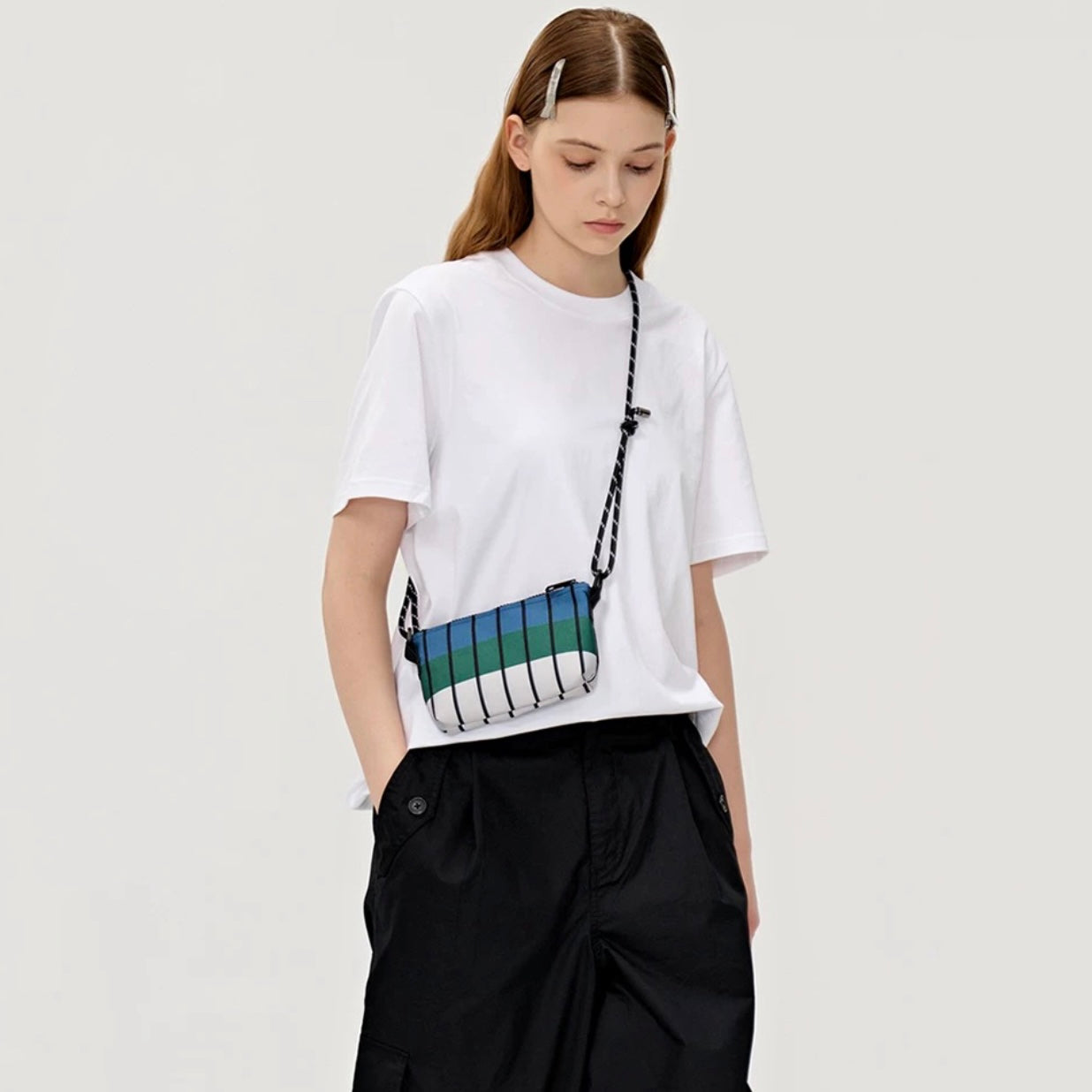Model wearing the FREEIN designer striped bag in a high-waisted crossbody style for a trendy urban look.