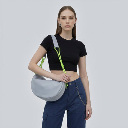 Model wearing the grey nylon crescent bag with knotted neon green  straps.